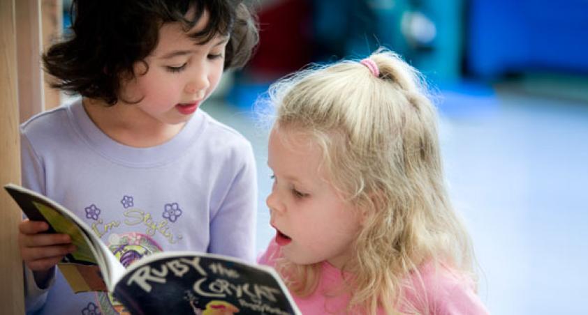 Two children reading a book